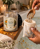 A jar of Herbal Bliss Healing Waters Special Bath Salt is shown next to a person&